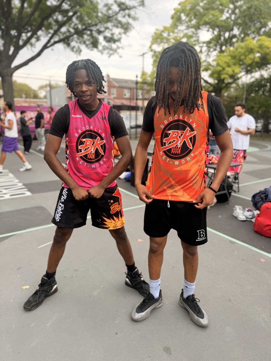 Two players in pink and orange Brooklyn Net-Work jerseys on the court